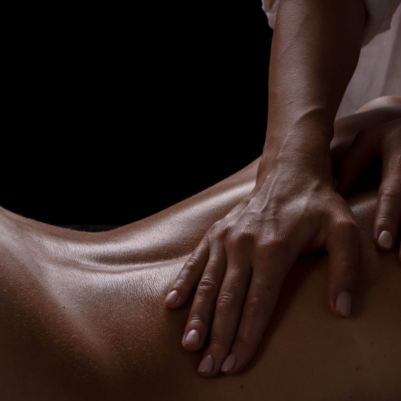 masser-girl-makes-massage-closeup-dark-background-closeup-massage